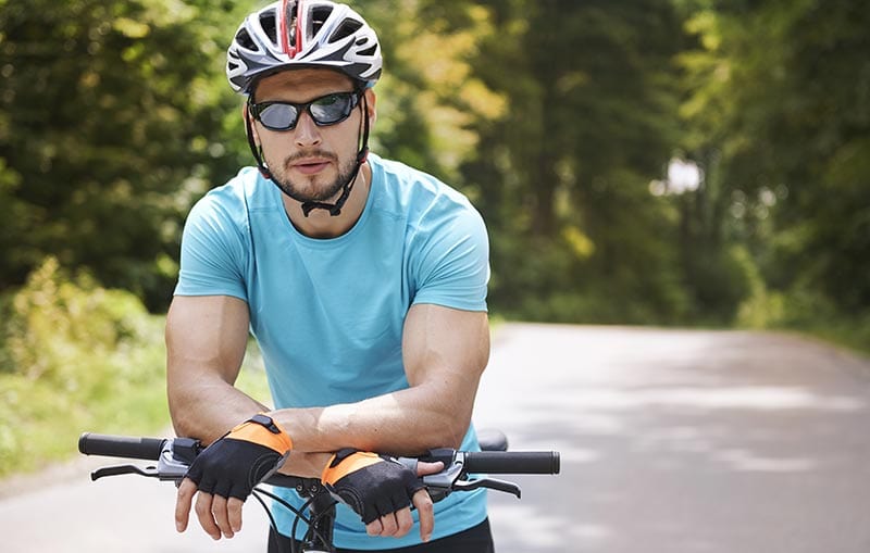 Mann auf Fahrrad mit Sportbrille und Helm